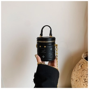 Detailansicht der schwarzen Mini-Beuteltasche mit Lederstruktur und goldener Kette