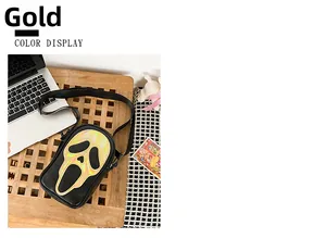 Detail of crossbody bag with golden holographic Scream ghost mask on black leather