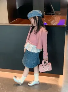 Girl modeling pink quilted crossbody bag with pearl handle and stylish outfit