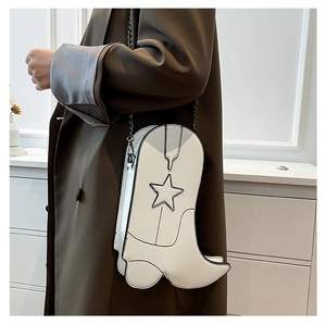 Detail of white boot-shaped crossbody bag with black star motif and dark chain strap