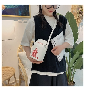 Detailed view of white take-out box style crossbody bag with red tower print and chain strap
