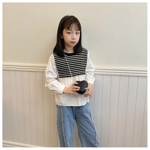 Détail d'un petit sac bandoulière noir en forme de cœur avec chaîne pour enfants