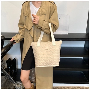 Chic beige quilted tote bag with large capacity held by model in casual lifestyle setting