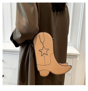 Detail of creative cowboy boot shaped crossbody bag with star decor and chain strap