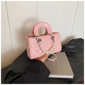 Detail of pink quilted crossbody bag for kids featuring a large pearl chain handle