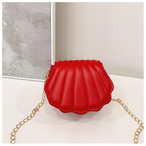 Détail d'un joli sac bandoulière rouge en forme de coquillage avec chaîne dorée