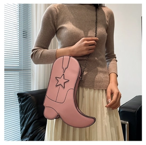 Close-up of pink boot-shaped shoulder bag with star detail and metal chain strap
