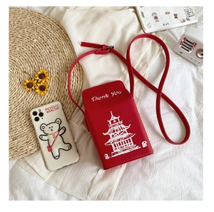Detailed top view of red PU leather crossbody bag with Thank You print and accessories