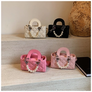 Detail showing four quilted mini crossbody bags with elegant pearl handles and metal rings