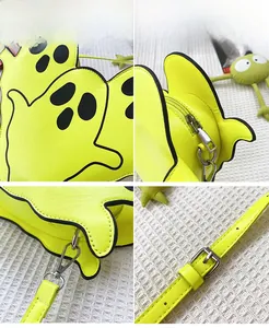 Detail of neon yellow ghost bag showing silver zipper, metal hooks and black printed face