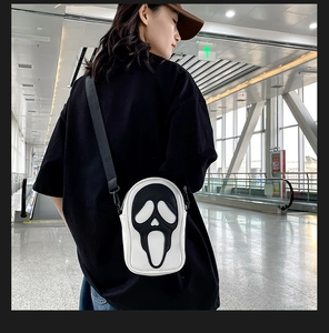 Detailed close-up of a white shoulder bag featuring a black Ghostface mask patch