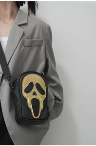 Detail of crossbody bag featuring a laser gold Ghostface mask applique on black PU leather