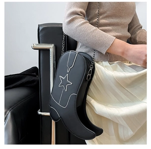 Creative black leather boot-shaped crossbody bag with silver chain strap shown on model