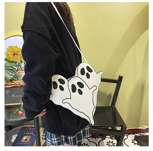Funny ghost-shaped crossbody bag made of white PU leather shown on a shoulder
