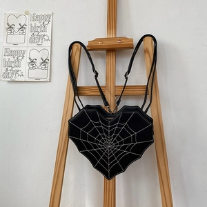 Black heart-shaped backpack with white spider web stitching and slim straps