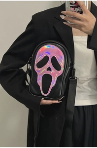 Detail of crossbody bag featuring a holographic scream face design with black nylon strap