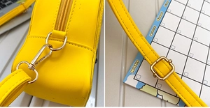 Macro shot of bright yellow PU bag hardware with gold metal hooks and stitching details