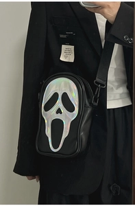 Mirror selfie showing the laser Ghostface pattern on a black crossbody handbag