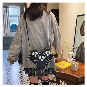 Girl wearing creative black crossbody bag with white cartoon ghost prints on grey sweatshirt