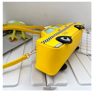 Detail of creative yellow taxi-shaped shoulder bag with NYC TAXI branding and metal hooks