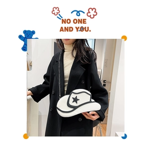 Detail showing creative white cowboy hat bag with black star and metal chain strap