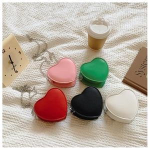 Détail de mini sacs en forme de cœur en cinq couleurs avec chaînes métalliques fines