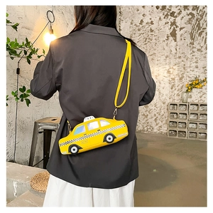 Detail showing the yellow taxi car shoulder bag worn by a model in an industrial setting