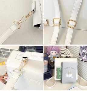 Detailed views of gold metal hardware and fine stitching on a white leather shoulder bag