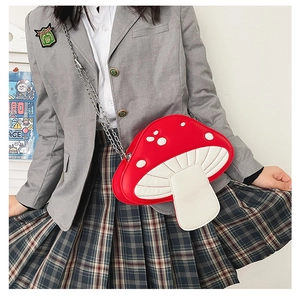 Close-up of cute red and white mushroom shoulder bag with metallic chain and stitching