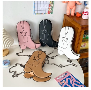 Close-up of four cowboy boot shaped crossbody bags with star stitching and metal chains