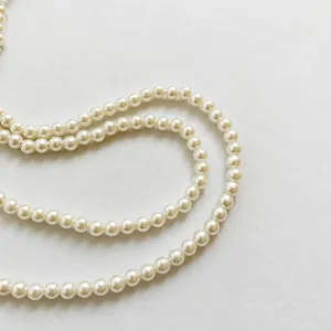 Macro shot of high quality round cream pearls and luxury strap texture on the bag