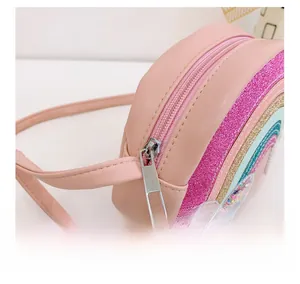 Detail view of smooth metal zipper and colorful glitter rainbow stripes on pink kids bag