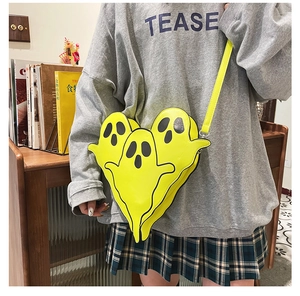 Detail of three layered neon yellow ghost-shaped crossbody bags made of smooth PU leather