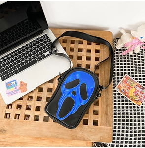 Close-up of a black crossbody bag with a blue holographic scream mask design and strap