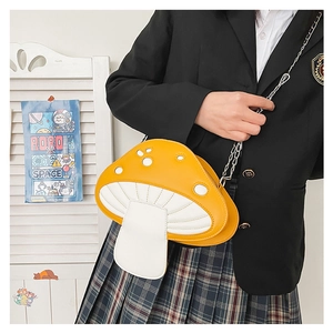 Detail shot of a yellow and white mushroom-shaped chain bag worn on a shoulder