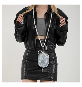 Détail d'une mini pochette en jean bleu avec nœud en perles et longue bandoulière