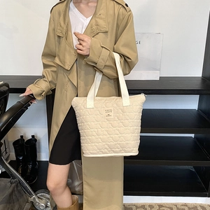 Quilted beige tote bag with chic heart pattern and spacious interior for daily use