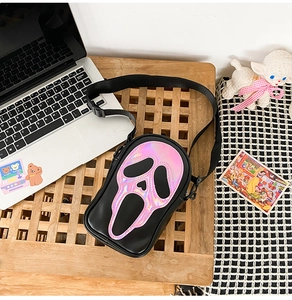 Detail of laser reflective Ghostface pattern with pink stitching on black crossbody bag