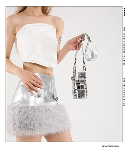 Detail of silver metallic mini bucket bag with wide strap and futuristic mirrored finish