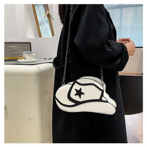 Detail shot of a white cowboy hat shaped crossbody bag with black star patch and chain strap