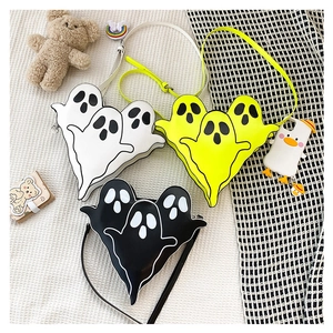 Detailed view of three ghost-shaped crossbody bags in white, black, and bright yellow PU leather