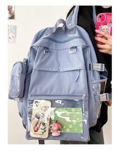 Detail of light blue nylon backpack with transparent multi-pocket design and side bag