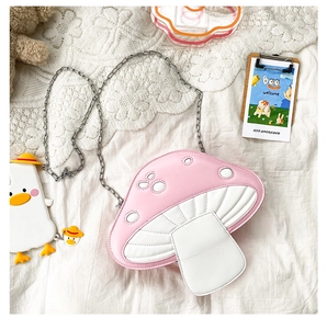 Detail of pink mushroom crossbody bag with quilted texture and cute duck charm accessory