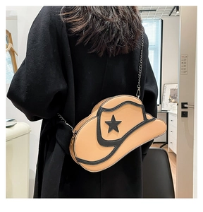 Detail of creative cowboy hat shaped shoulder bag in camel with star accents and chain