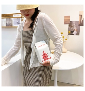 Detailed view of the creative takeout box crossbody bag with tower print and chain strap