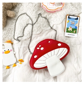 Detailed stitch work on red mushroom cap with white polka dots and silver chain strap