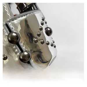 Detail showing silver mirror leather surface with metal studs and double stitching