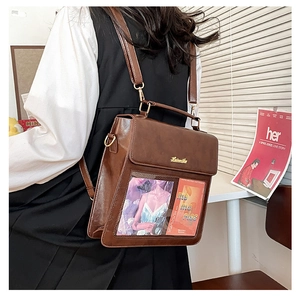 Detail of brown leather multi-way bag with transparent PVC window and gold hardware
