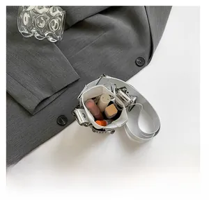 Detail view of silver bucket bag interior holding several lipsticks and small cosmetics
