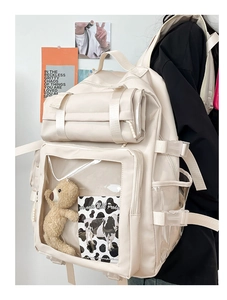 Detail view of the cream student backpack showing transparent window pocket and side buckle
